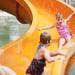 Madison Lamb, 3, rides down the water slide with her brother Elijah and her cousin Zoey Andrews at Blue Heron Bay at Independence Lake County Park on Saturday, July 6. Daniel Brenner I AnnArbor.com